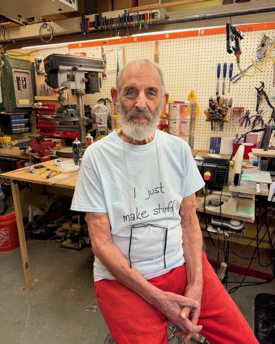 Harvey Fein in his workshop, wearing a T-shirt that says I just make stuff